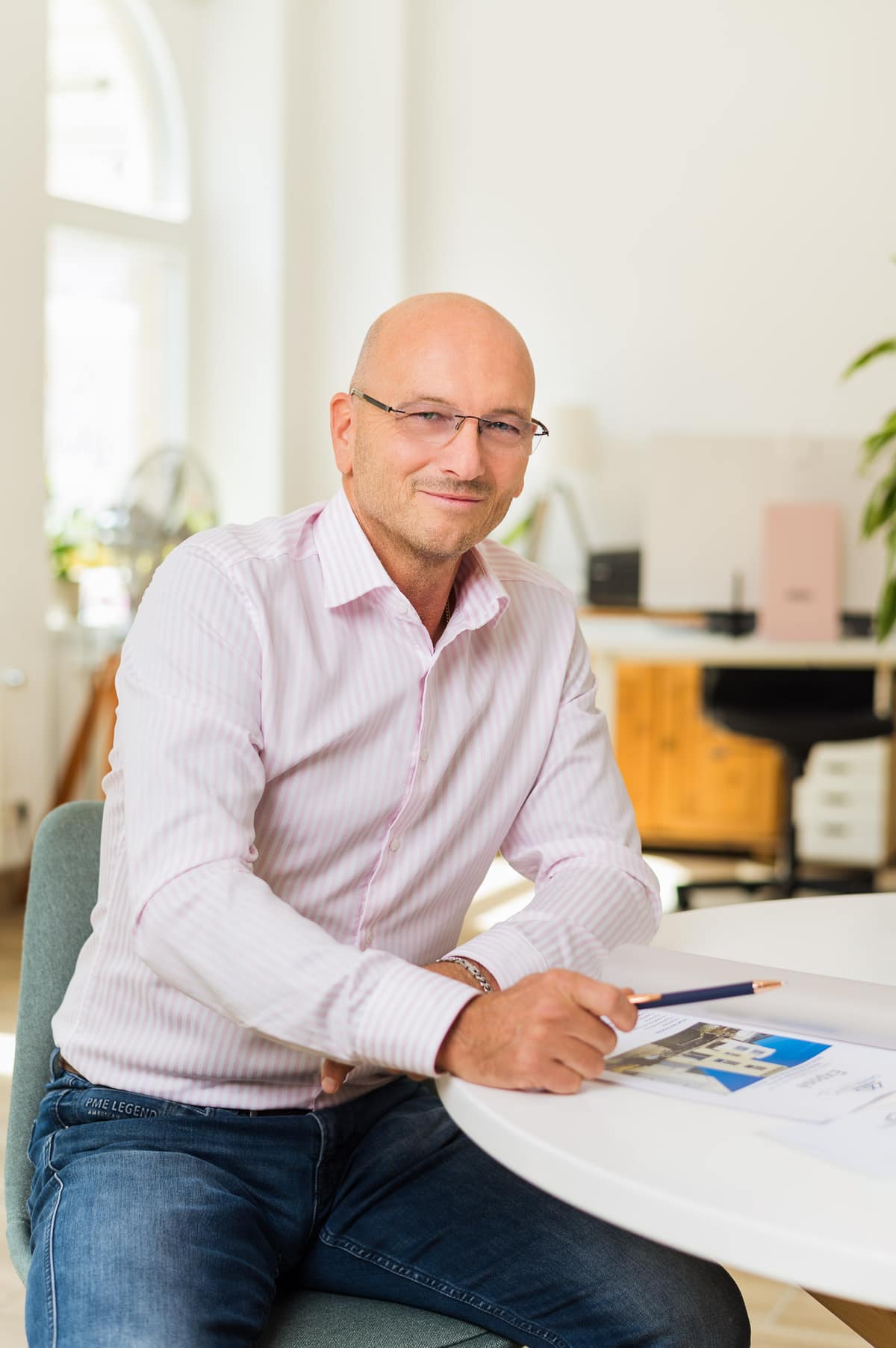 André Sempert am Besprechungstisch mit einem Exposé